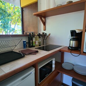 Una cocina compacta con encimera, cafetera, tostadora y lavavajillas.