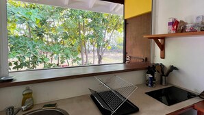 A kitchen with a window, sink, and a dish rack. - Beach bungalow: Balaou (Le Carbet)