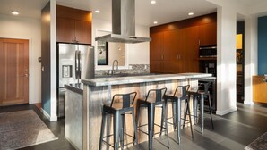 A modern kitchen with a central island, stainless steel appliances, and wooden cabinets. - Bellingham Adventure Home: 4BR Retreat w/ Yard Near Trails (Bellingham)