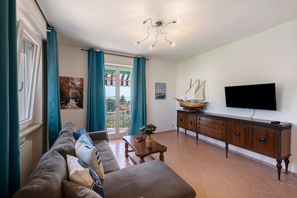 A living room with a sofa, a wooden coffee table, a TV, and a cabinet. - Apartment 'Il Boma - Capitan Libeccio' with Lake View, Wi-Fi and Air Conditioning (Garda)