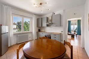A modern kitchen with a dining table, cabinets, and a view to the outside. - Apartment 'Il Boma - Capitan Libeccio' with Lake View, Wi-Fi and Air Conditioning (Garda)