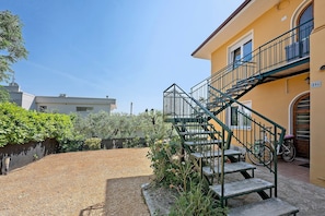A building with a staircase, a door, and a bicycle. - Apartment 'Il Boma - Capitan Libeccio' with Lake View, Wi-Fi and Air Conditioning (Garda)