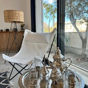 A modern room with a white chair, a large window, and a tray with glasses and a teapot. - La Casa Verde , Duplex in the Heart of La Marsa (La Marsa)