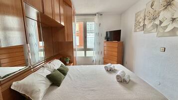 1 dormitorio, tabla de planchar con plancha, ropa de cama