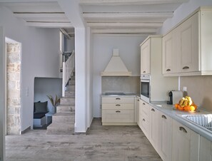 Eine moderne Küche mit Holzschränken, einem eingebauten Backofen und einer Arbeitsplatte mit Obst.