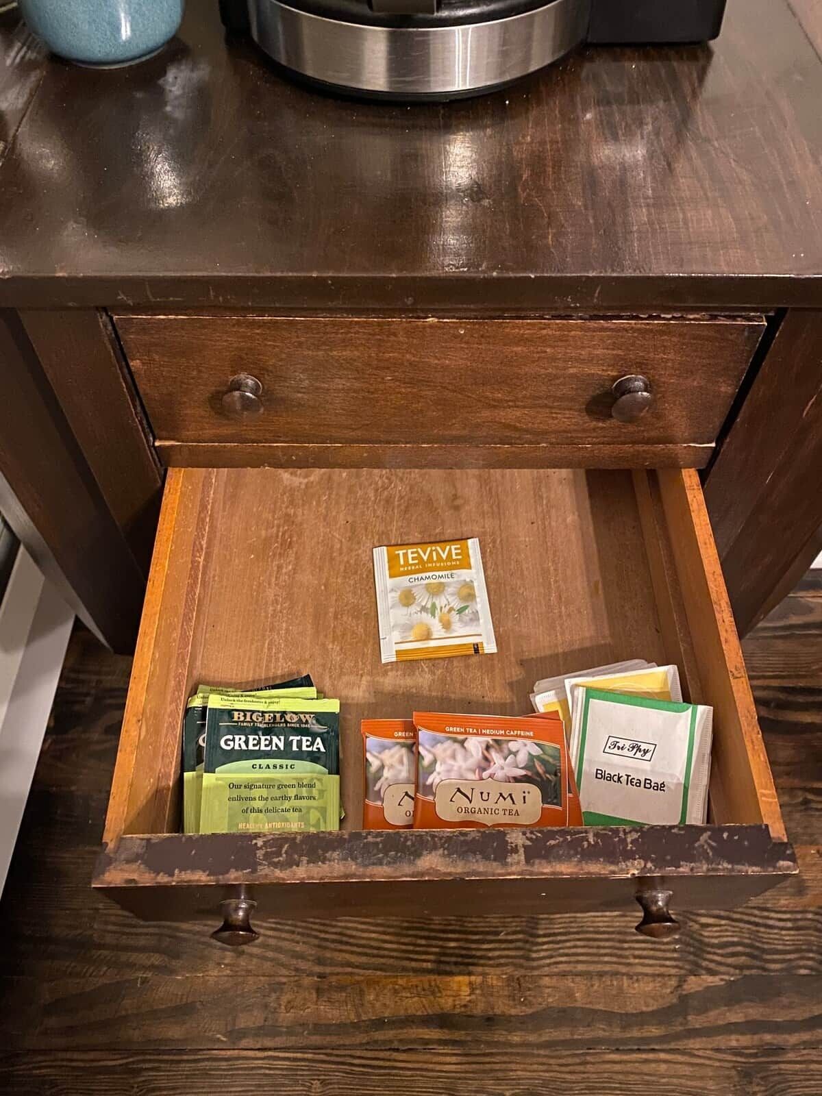 A wooden drawer with a tea bag inside.