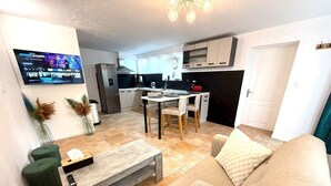 Un salon moderne avec un canapé beige, une table basse et un téléviseur fixé au mur.