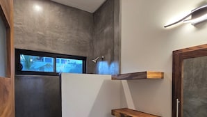 Une salle de bain moderne équipée d’une douche, de toilettes et d’un meuble-lavabo.