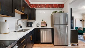 A modern kitchen with dark cabinets, stainless steel appliances, and a white countertop. - Best Location! Walk to Broadway & Downtown! Balcony-2 Car Parking-Laundry-Wi-fi (Nashville)