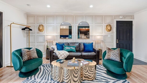 A living room with a dark green sofa, a matching armchair, a round coffee table, and a patterned rug. - Best Location! Walk to Broadway & Downtown! Balcony-2 Car Parking-Laundry-Wi-fi (Nashville)