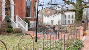 A brick building with a sign for 'Husk Restaurant' and a staircase leading to the entrance. - Best Location! Walk to Broadway & Downtown! Balcony-2 Car Parking-Laundry-Wi-fi (Nashville)