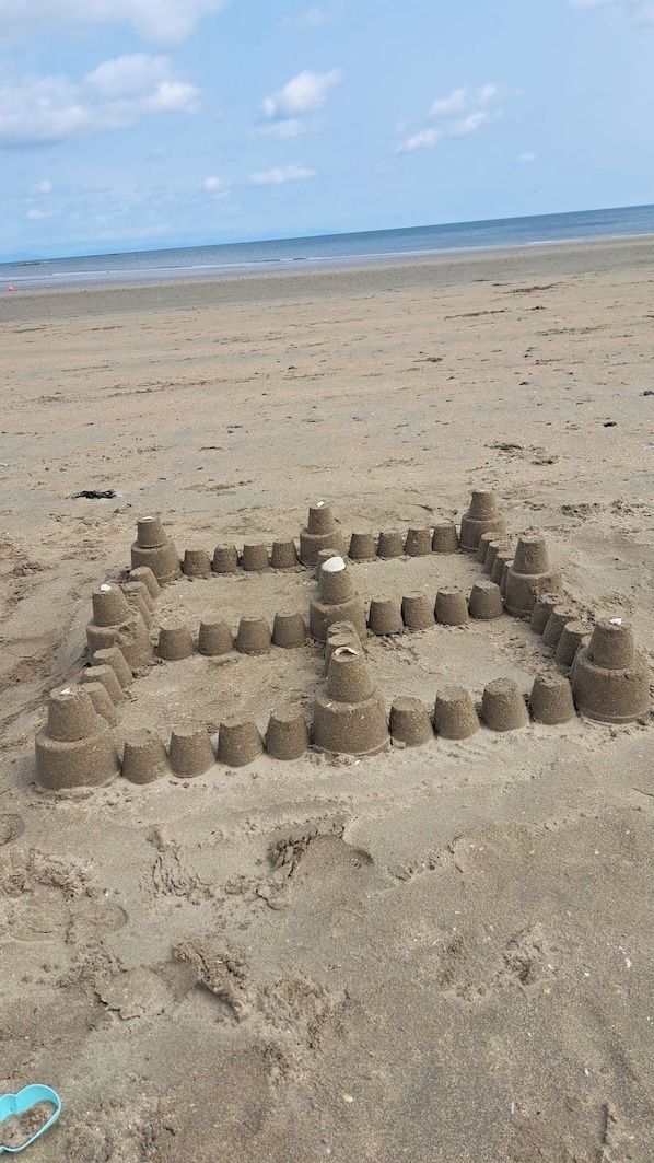 A sandy beach with a large sand sculpture of a face. - 2 Bedroom Apartment 4-6 People-coastal Comfort (Balbriggan)
