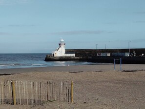 A lighthouse by the sea with a wooden fence in the foreground. - 2 Bedroom Apartment 4-6 People-coastal Comfort (Balbriggan)