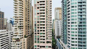 Un edificio residencial de gran altura con varios balcones, un diseño arquitectónico moderno y un entorno urbano denso.