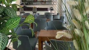 Et moderne interiør med barområde, siddepladser og dekorative planter.