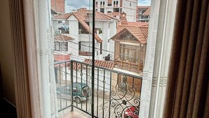 Ein Balkon mit Blick auf Wohnhäuser und einen bewölkten Himmel.