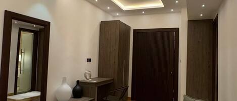 A modern bedroom with a bed, a desk, a chair, and a sofa.