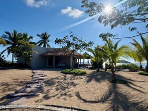 A beachside property with a covered patio, palm trees, and a view of the ocean. - CASA IYARI - Chamela (​Municipio de la Huerta​, Chamela)