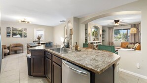 A modern kitchen with granite countertops, stainless steel appliances, and a central island. - Private Pool Oasis. Perfect for Summer & Family Visits (Phoenix)