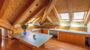Una cocina amplia con vigas de madera, una isla grande y tragaluces.