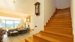 A spacious living area with a wooden staircase leading to an upper floor. - Villa Citriodora  Cernobbio (Cernobbio)