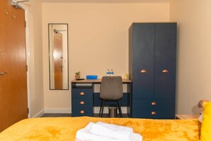 A bedroom with a bed, a desk, a chair, a wardrobe, and a mirror. - Warrington 5 (Double rooms) (Warrington)
