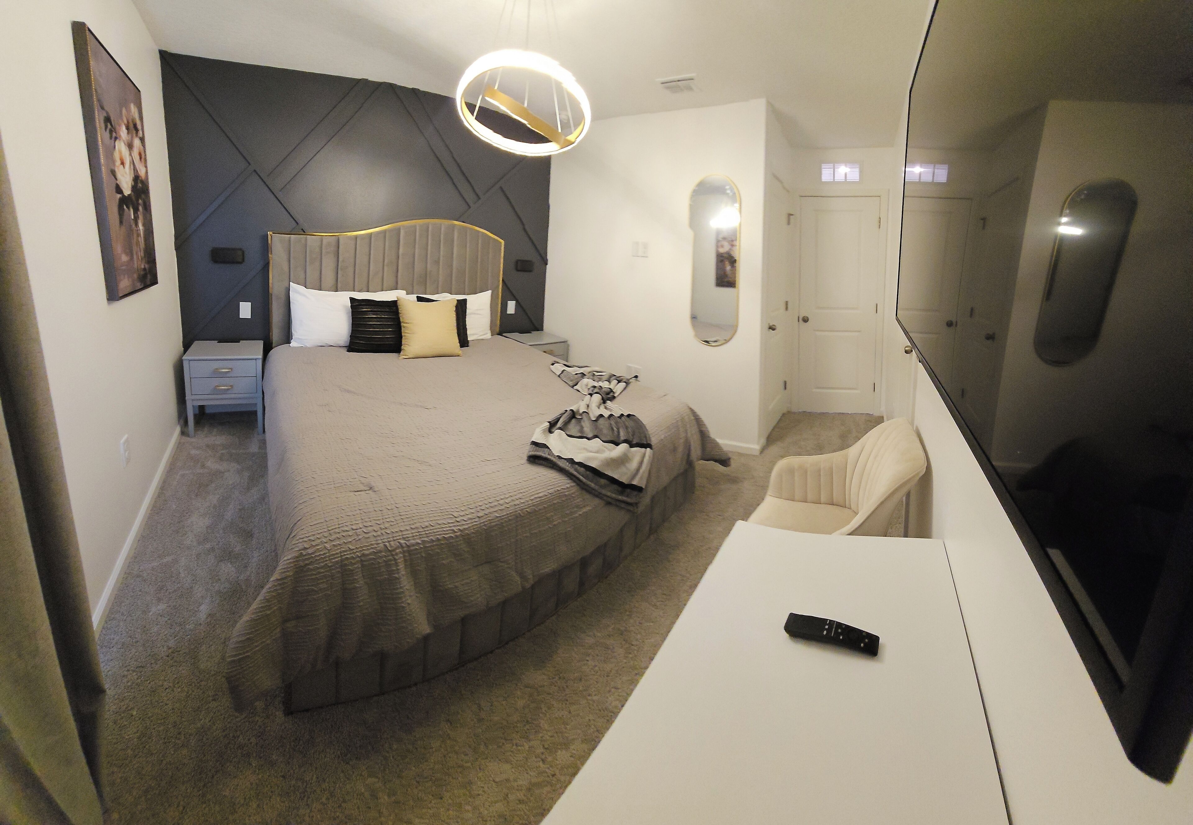Un dormitorio con cama, mesita de noche y televisión.