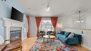 Ein Wohnzimmer mit Kamin, einer Couch, einem Couchtisch und zwei Sesseln.