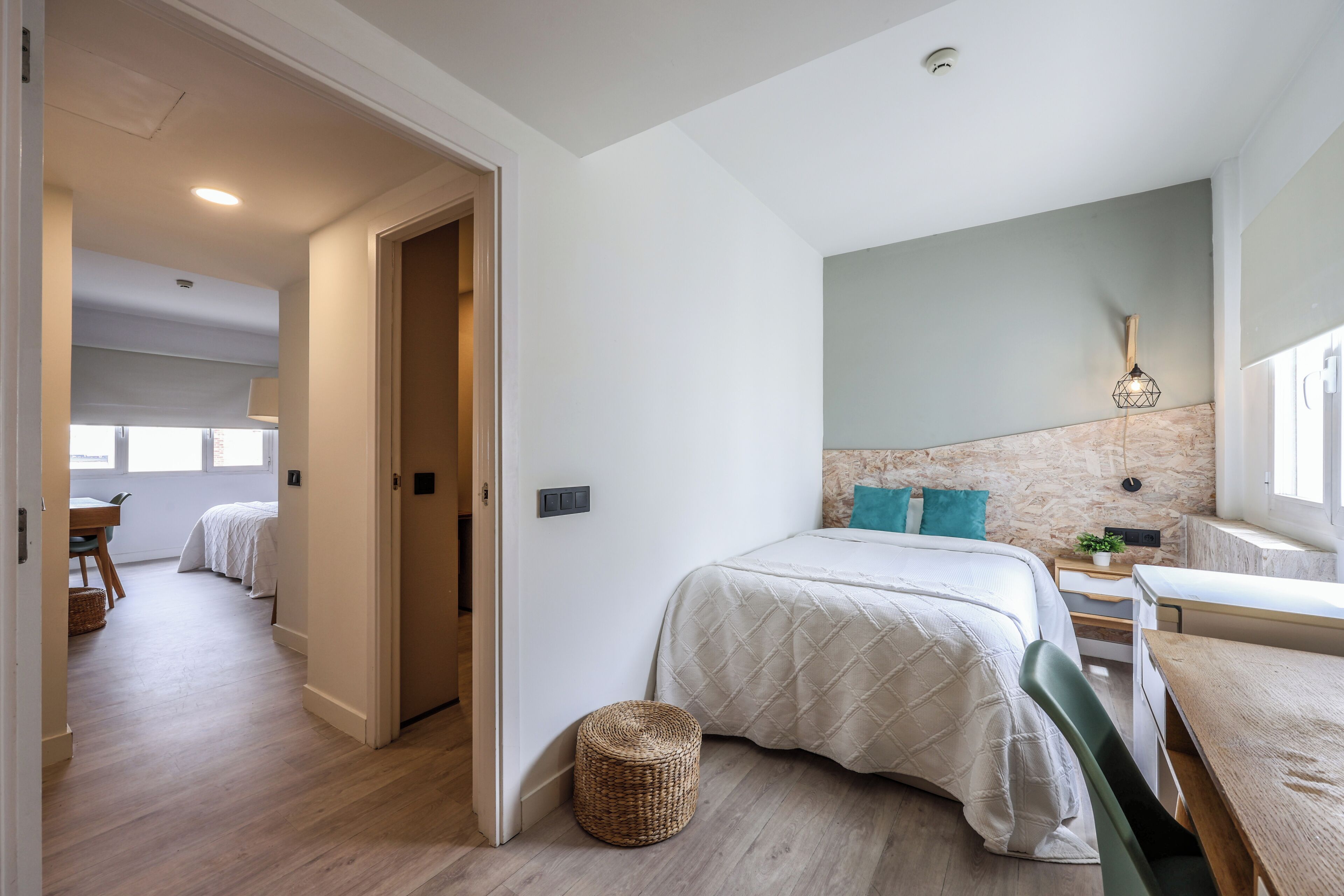 Une chambre à coucher avec un lit, une table de chevet et une fenêtre.