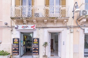 Un bâtiment avec une enseigne indiquant « Araga Menù » et un pot de fleurs devant l’entrée.