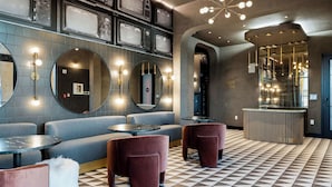 A modern lounge area with seating, a reception desk, and a patterned floor.