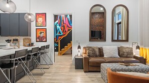 Un espacio habitable moderno con cocina, comedor y un sofá con televisor.