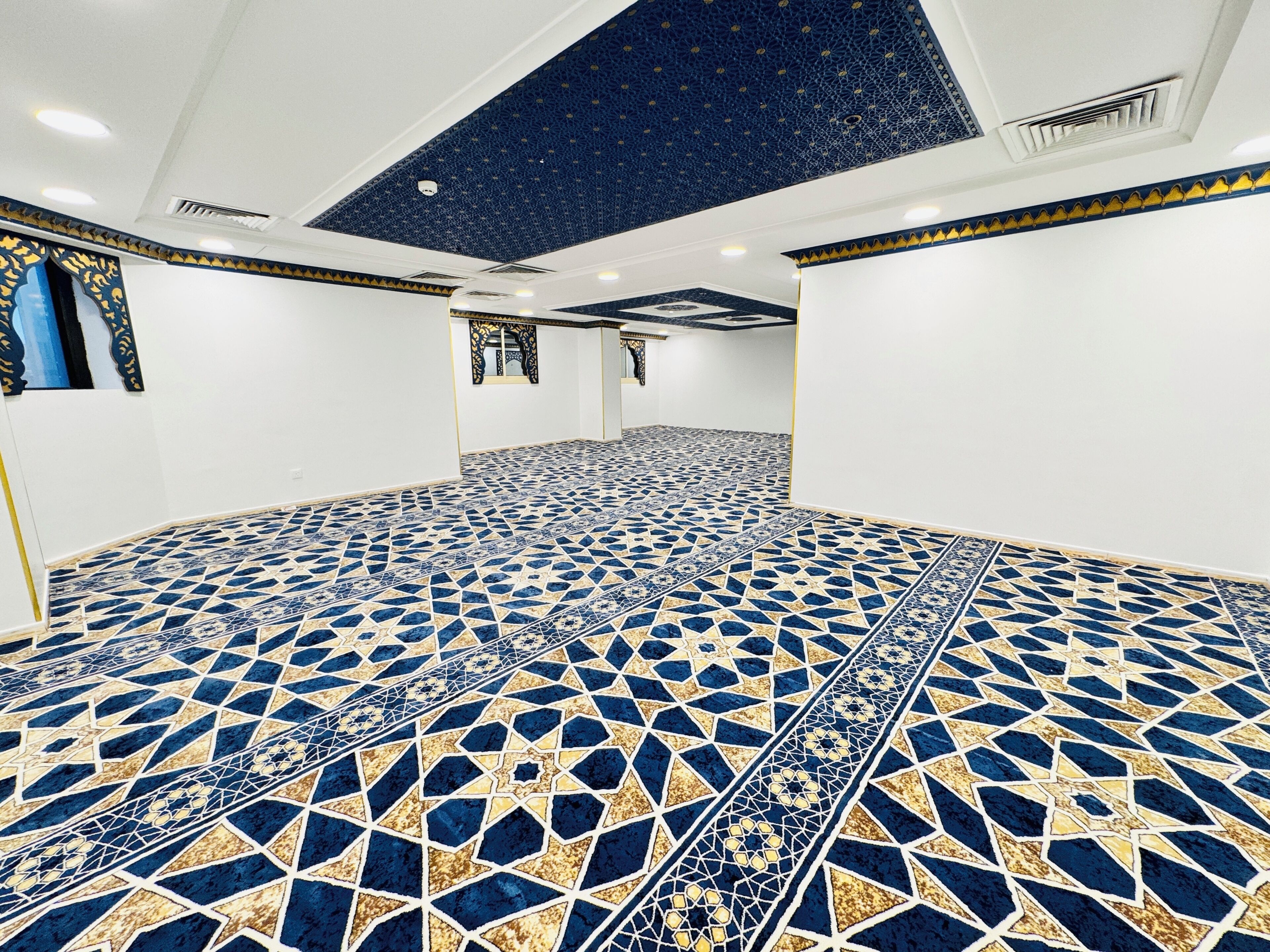 Una habitación con piso de estampado geométrico, paredes blancas y techo con diseño de estrellas.