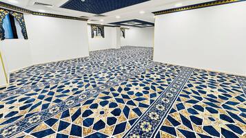 Una habitación con piso de estampado geométrico, paredes blancas y techo con diseño de estrellas.