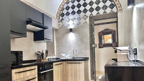 Una cucina moderna con isola centrale, forno integrato e una decorativa piastrella a mosaico.
