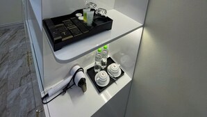 A hotel room with a minibar, a coffee machine, and a tray with toiletries. - Happy House ( Villa & Apartment ) ! (Cat Ba , Cat Hai)