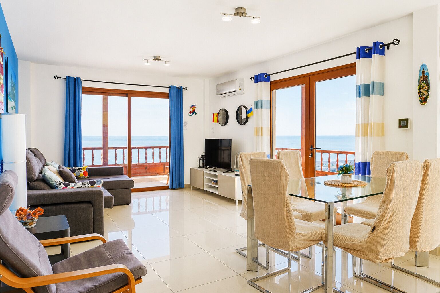 A modern living room with a balcony, a dining area, and a TV.