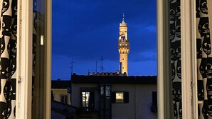 A window with a view of a tower against a twilight sky. - Between Duomo and Tower of Arnolfo, double view (Firenze)
