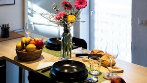 A dining area with a table set for two, featuring a fruit bowl, a vase with flowers, and a bread roll. - Between Duomo and Tower of Arnolfo, double view (Firenze)