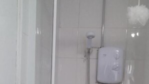 A shower area with a handheld showerhead and a wall-mounted control panel. - MIdway Hotel  (Blackpool)