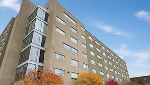 A multi-story building with a modern architectural design, featuring a mix of glass and brick facades. - Saint-paul Residence (Ottawa)