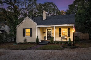 A single-story house with a front porch, a chimney, and a small front yard. - Spacious Summerville Cottage (Augusta)