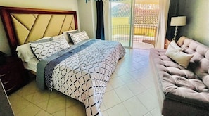 A bedroom with a bed, a sofa, and a balcony. - Beautiful villa a few steps from the sea (Puerto Vallarta)