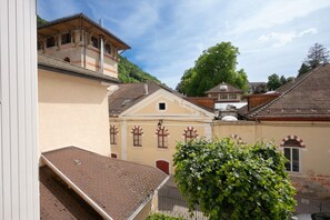 A building with a sloped roof, arched windows, and a small balcony.