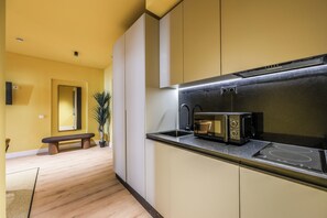 Deluxe suite, balkon, uitzicht op stad | Privékeuken | Een magnetron, een kookplaat, kookgerei, borden en bestek
