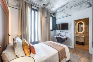 Een moderne hotelkamer met een groot bed, een bureau, een televisie en een badkamer.