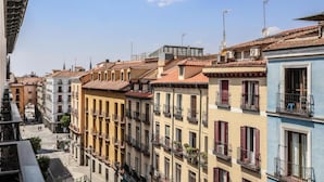 Une rangée de bâtiments colorés dotés de balcons, un ciel dégagé et une rue en arrière-plan.