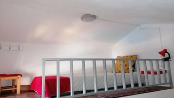 A room with a bed, a desk, a chair, a lamp, and a ceiling light.