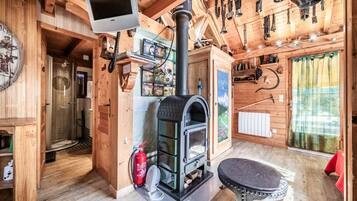 Ambiente in legno con camino, televisione e zona doccia.