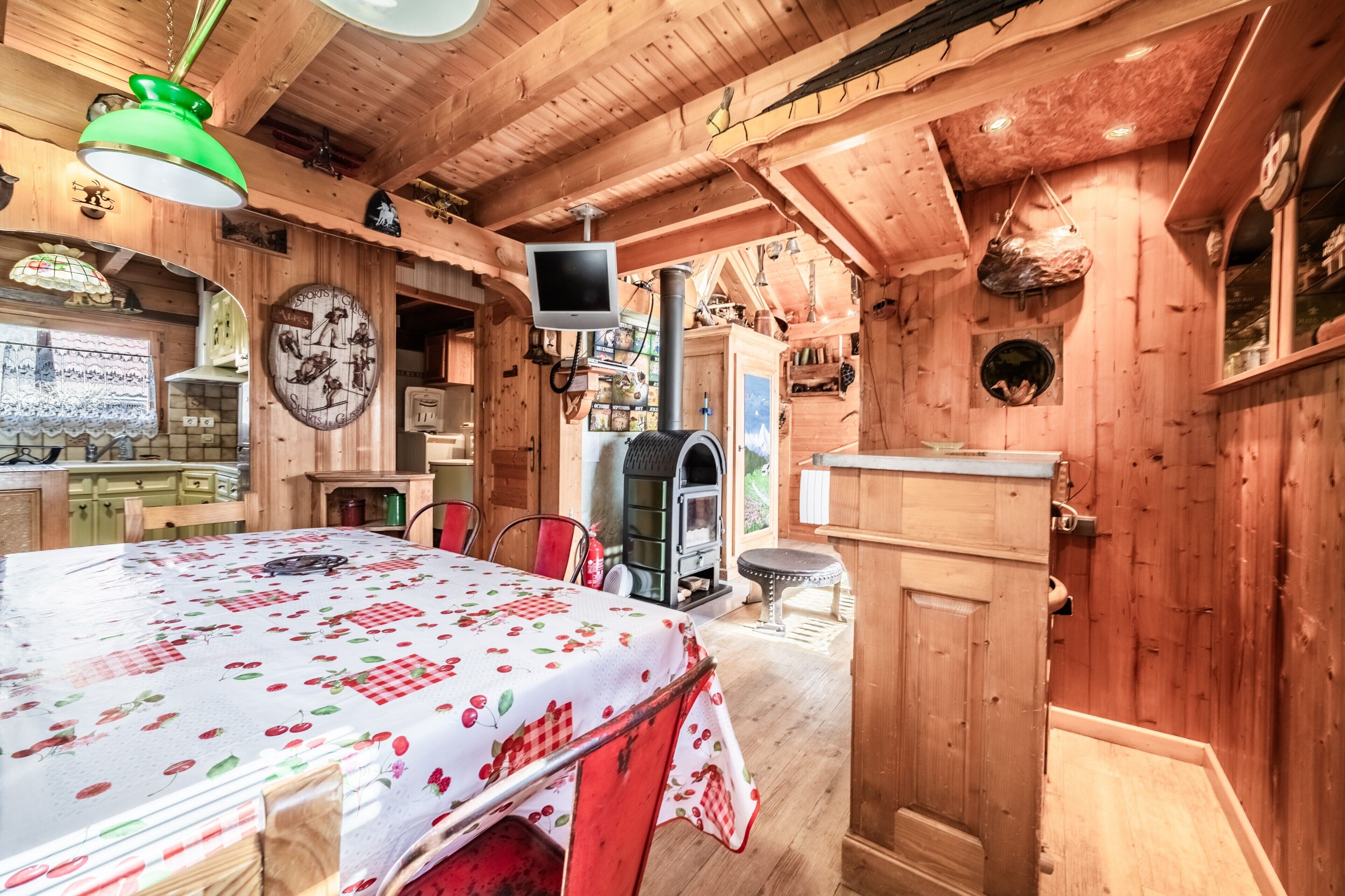 Una habitación acogedora de madera con cama, televisión, chimenea y zona de comedor.